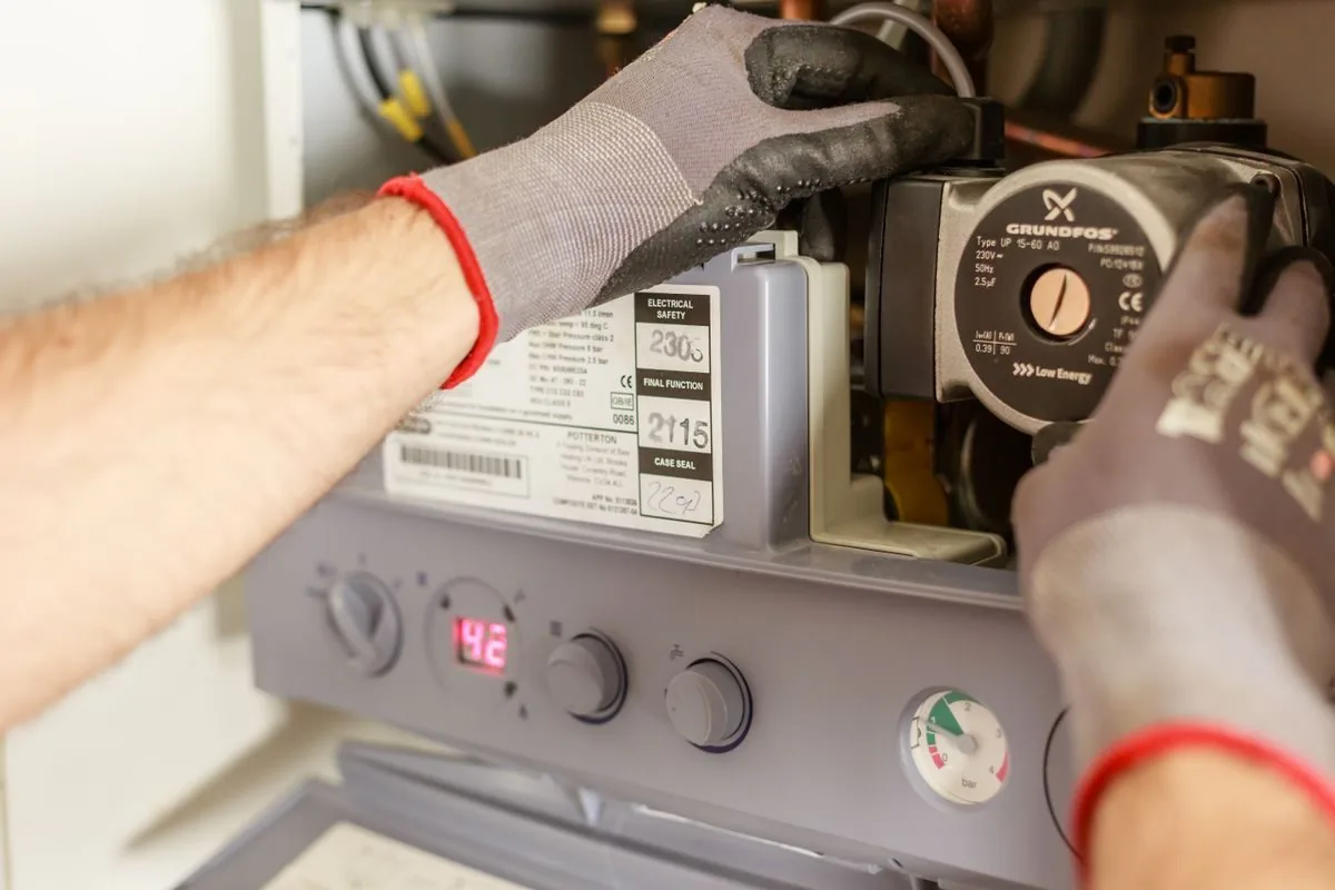 Técnico ajustando componentes de um sistema de aquecimento de água